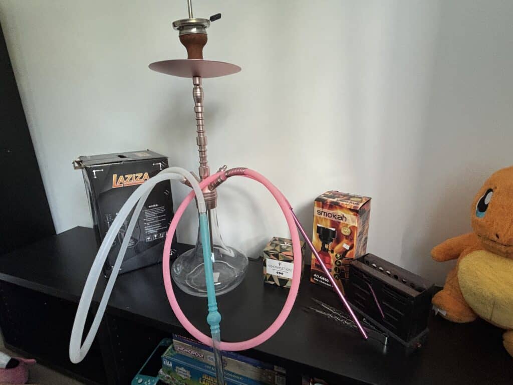 Shisha mit Silikonschlauch und Zubehör auf Tisch.