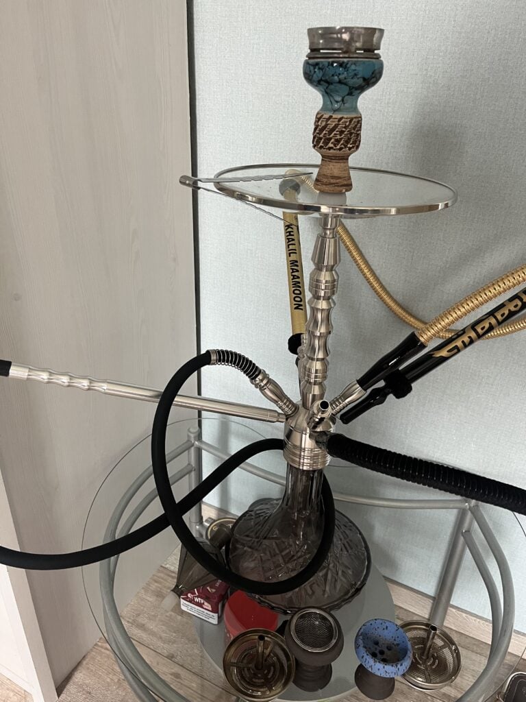 Shisha mit Glasbowl, Schlauch und Kohleteller, bereit zum Rauchen.