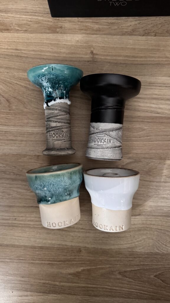 Vier Shisha-Headsets in verschiedenen Farben auf Holztisch.
