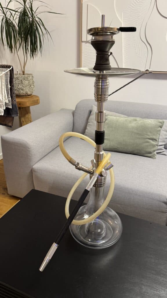 Moderne Shisha auf Tisch mit Rauchsäule im Wohnzimmer.