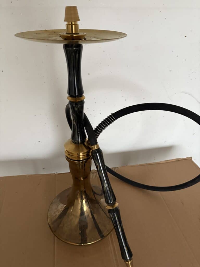 Rauch-Hookah mit goldener Basis, schwarzem Schlauch und Ablagefläche, ideal für Shisha-Liebhaber.