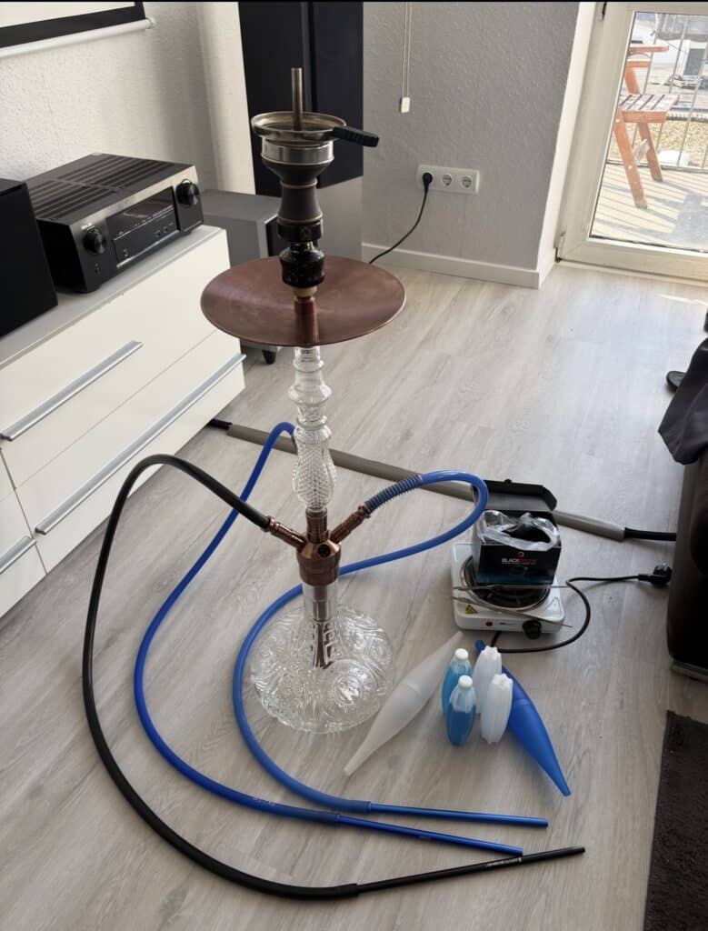 Wasserpfeife mit Glasbasis, Schlauch und Tabakkopf, ideal für Shisha-Liebhaber.