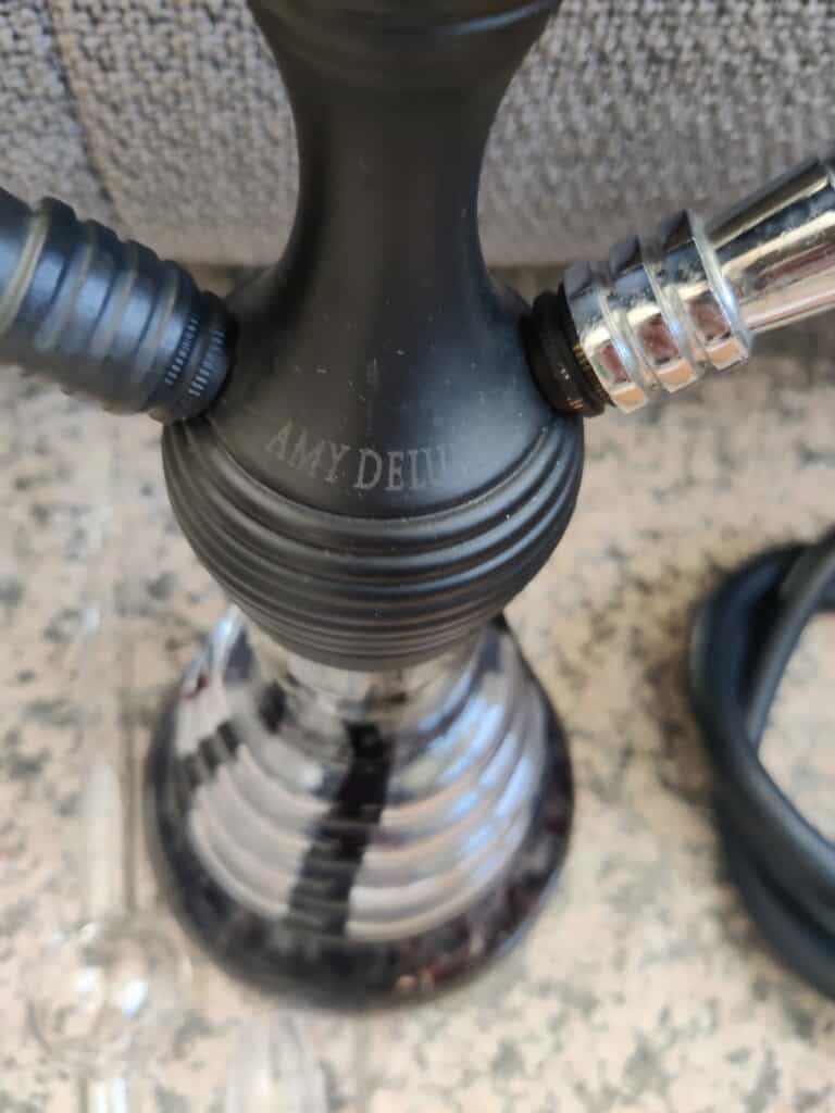 Schwarzer Shisha-Kopf mit Silikonschlauch und Glasbasis, ideal für Wasserpfeifen-Liebhaber.