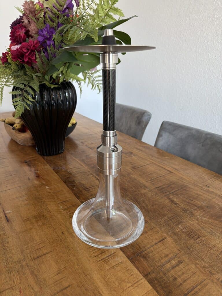 Rauchpfeife auf einer Glasbasis mit Metallaufsatz, ideal für Shisha-Genuss.