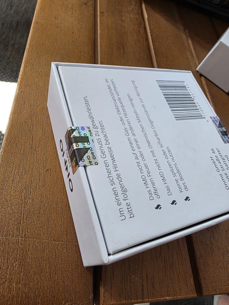 Barcoded Verpackung mit Text und Barcode, auf Holzplatte liegend.