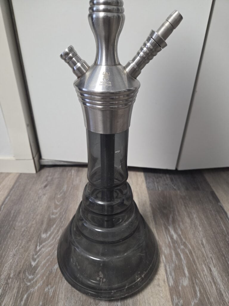 Wasserpfeife mit Metallaufsätzen, schwarzer Glasboden, für Shisha-Genuss.