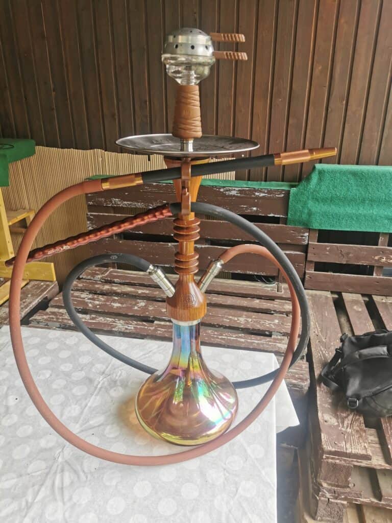 Rauchsäule mit Wasserpfeife, Shisha, Hookah auf Holzbank im Garten.
