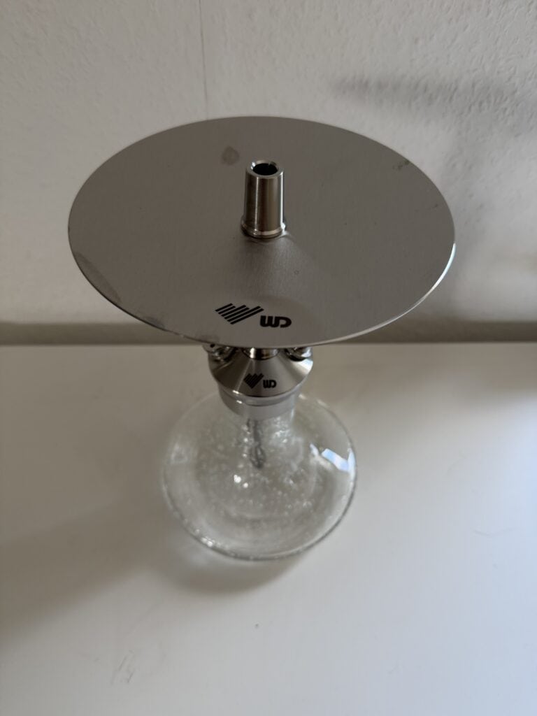 Leere Shisha Glasbowl mit Metallaufsatz auf weißem Hintergrund.