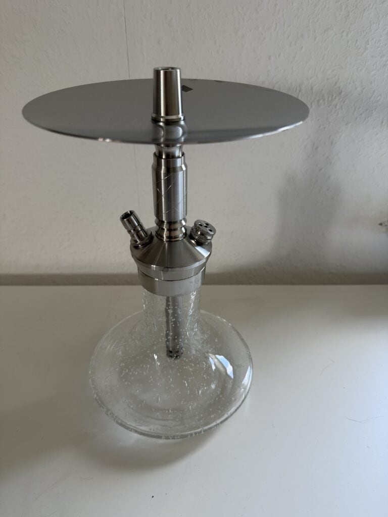 Stilvolle Shisha mit Metallaufsatz und Glasbowl auf weißem Hintergrund.