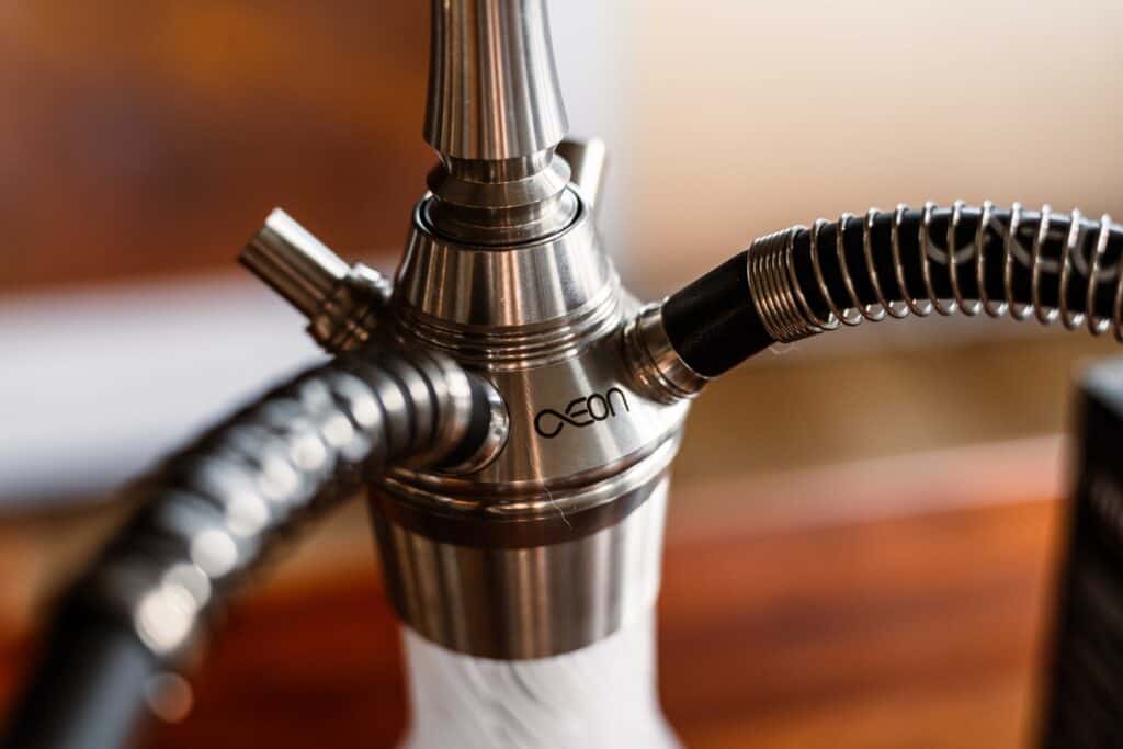 Nahaufnahme eines metallischen Shisha-Adapters mit Schlauchanschluss.
