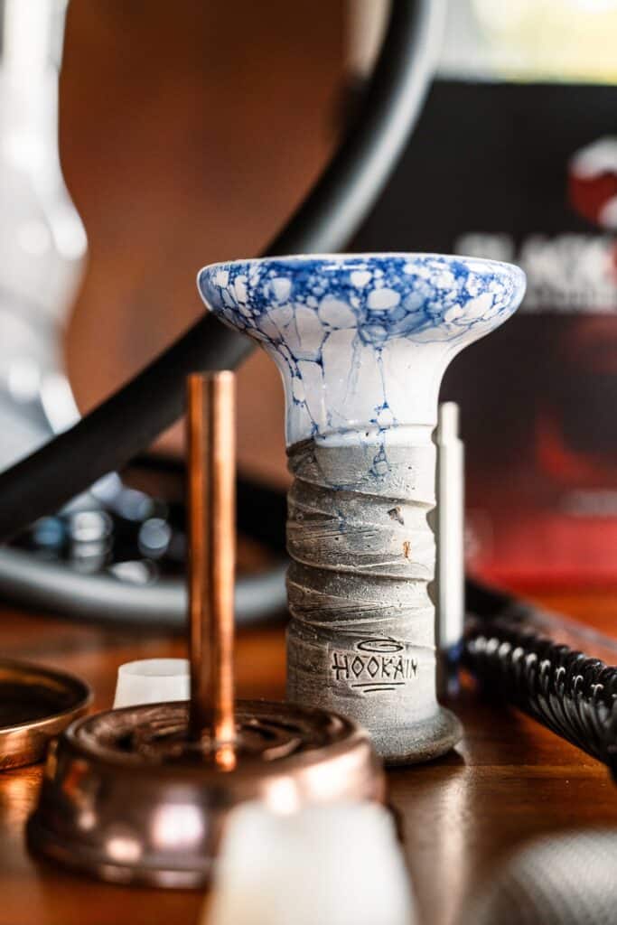 Bunte Shisha Glasbowl mit blauer Musterung auf Holz.