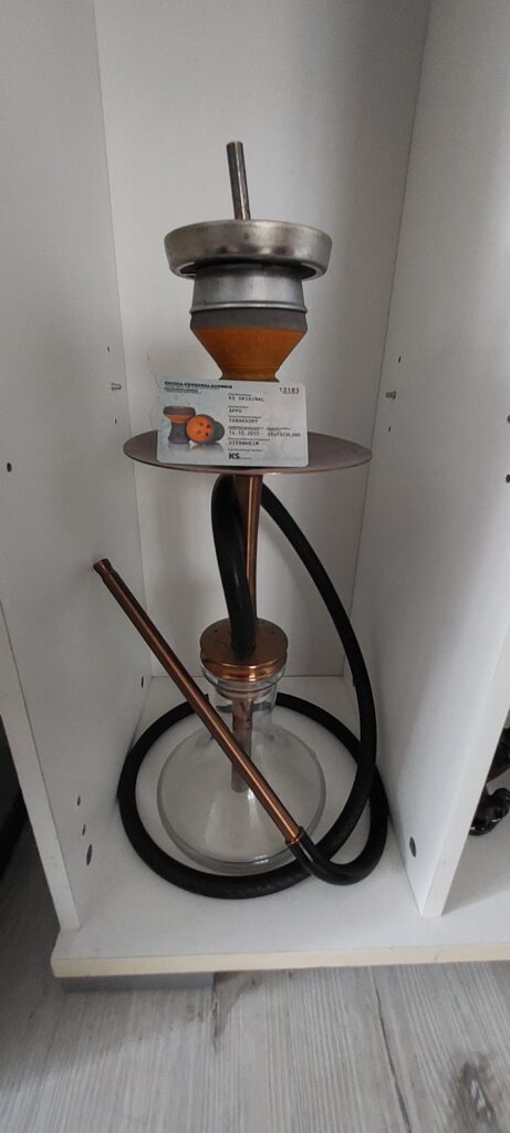 Shisha-Glasbowl mit Metallaufsatz und Schlauch.