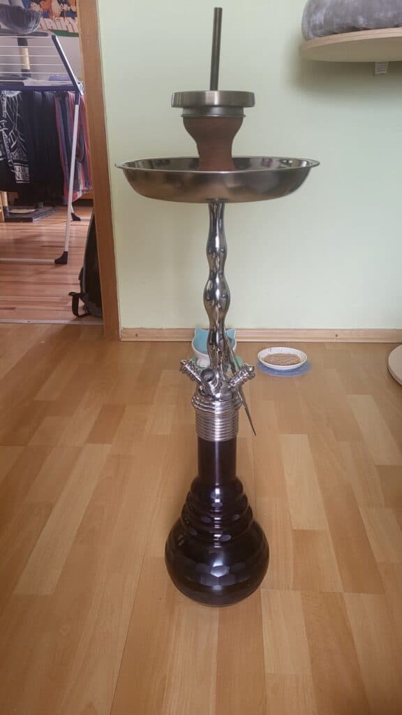 Hochwertige Shisha mit Metall- und Glasbowl, auf Holzboden.