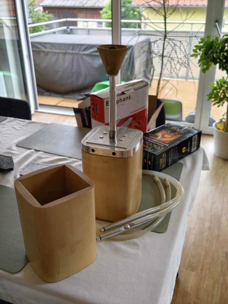 Shisha-Zubehör mit Glasbowl und Schlauch auf Tisch.