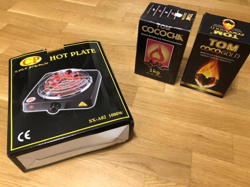 Verschiedene Shisha-Zubehörartikel auf Holztisch.