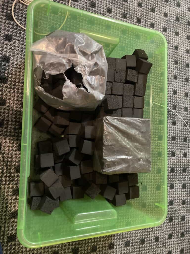 Verschiedene schwarze Shisha-Glasbowls und Zubehör in einer Box.