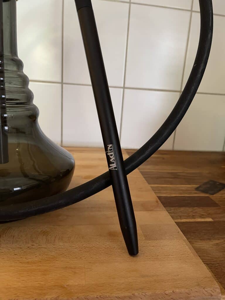 Schwarzer Shisha Schlauch und Glasbowl auf Holzuntergrund.