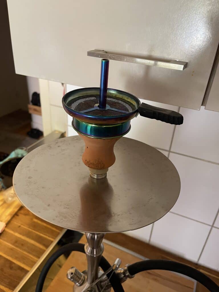 Bunte Glasbowl für Shisha mit Metallhalterung und Keramikbasis.