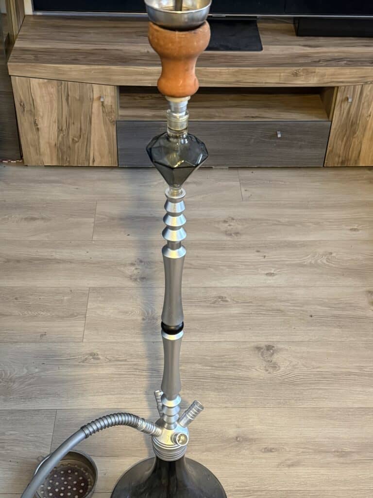 Shisha-Kamin mit Glasbowl und Metallrohr.