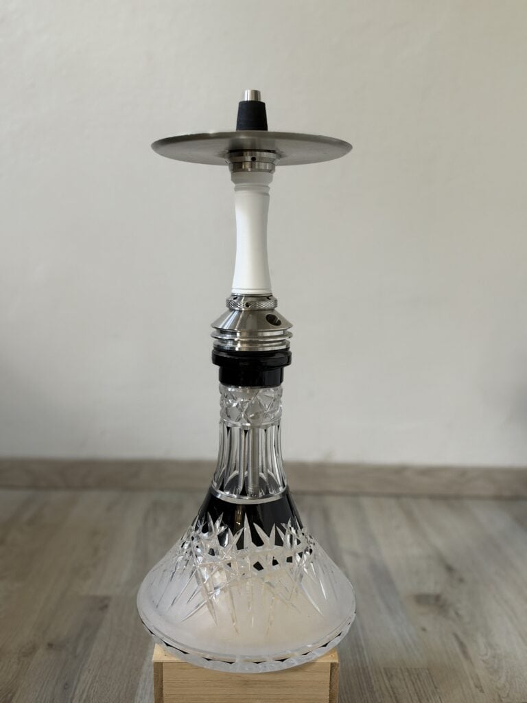 Schöne Shisha mit Glasbowl und Metallaufsatz auf Holzunterlage.