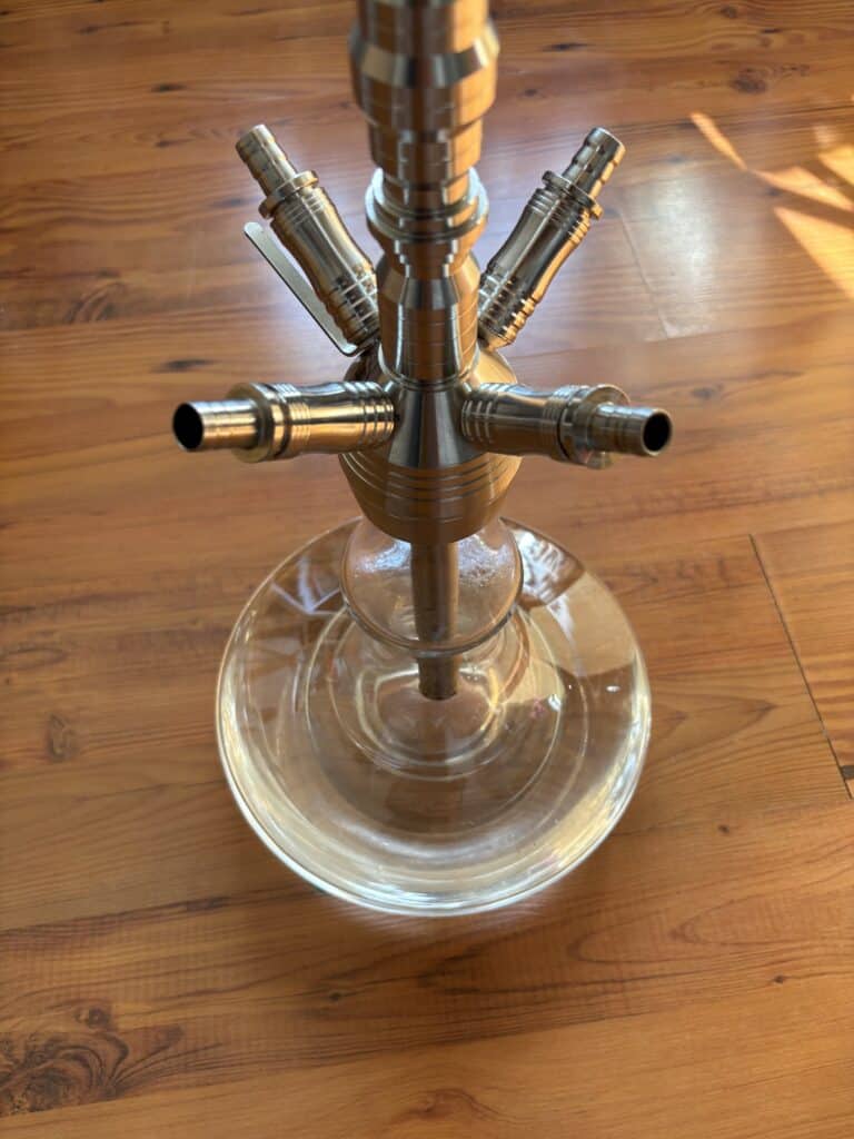Shisha mit mehreren Metall-Schlauchanschlüssen auf Holzfuß.
