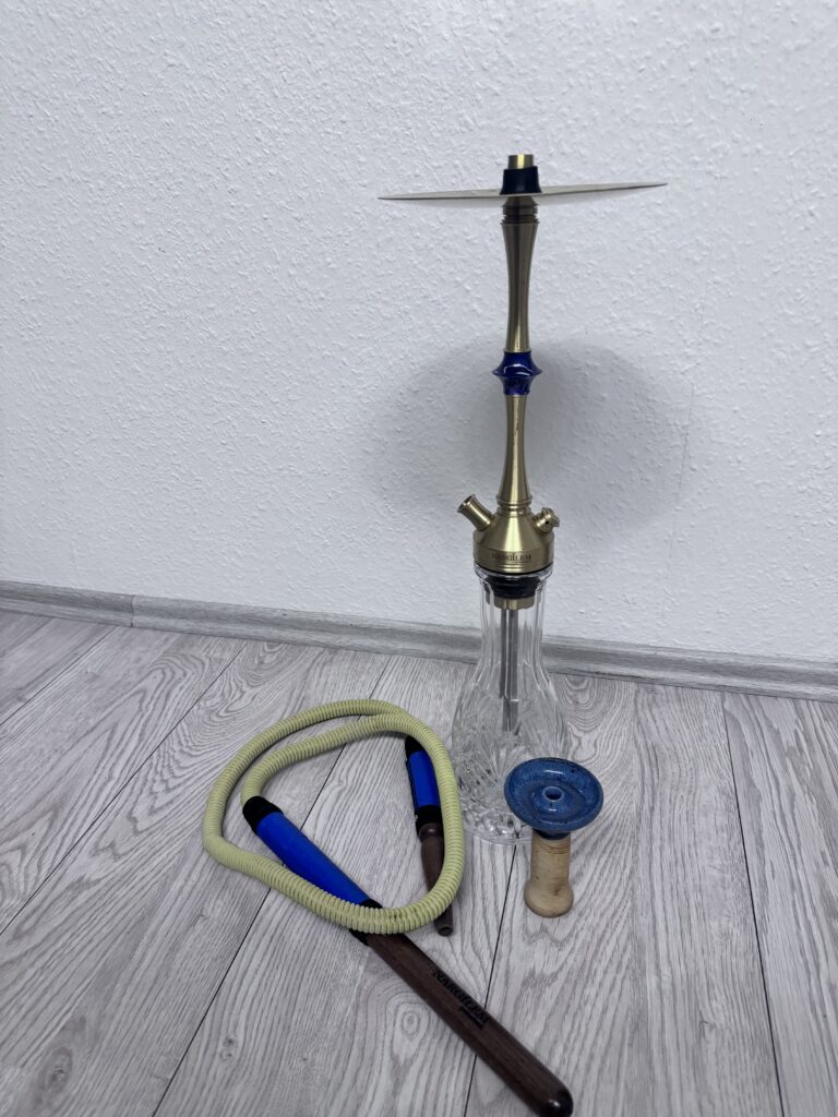 Verschiedene Shisha-Teile inklusive Glasbowl, Schlauch und Kopf.