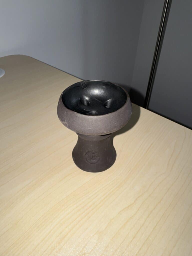 Schwarze und graue Shisha Glasbowl auf Holztisch.