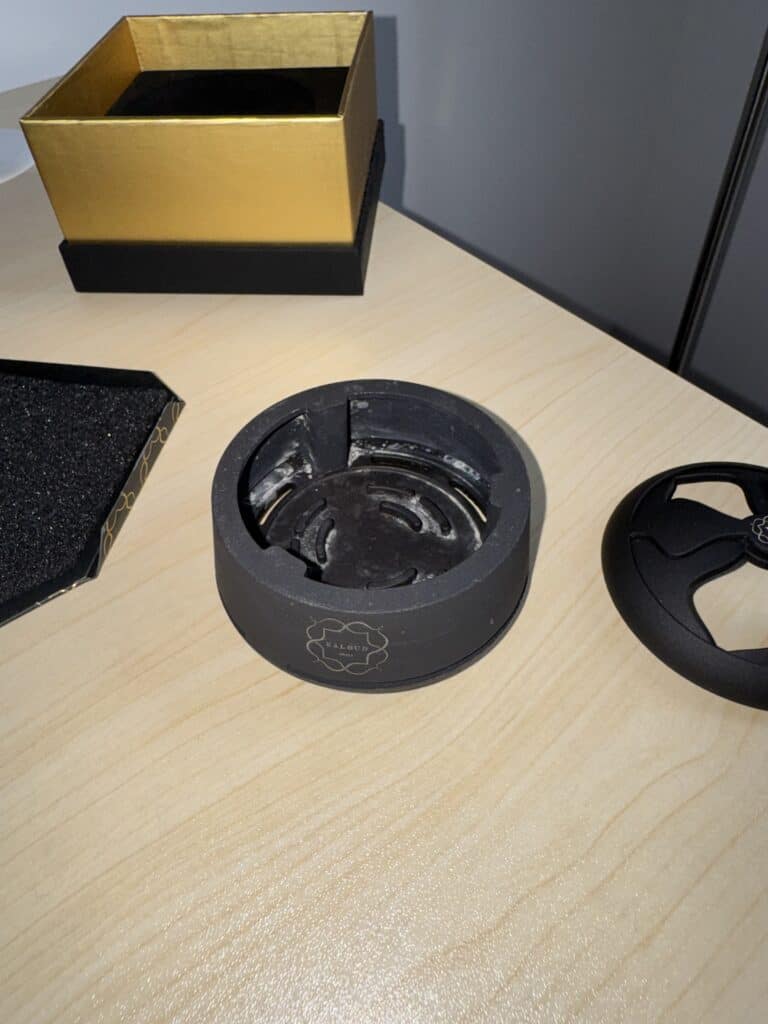 Schwarze Glasbowl für Shisha auf Tisch mit Zubehör.