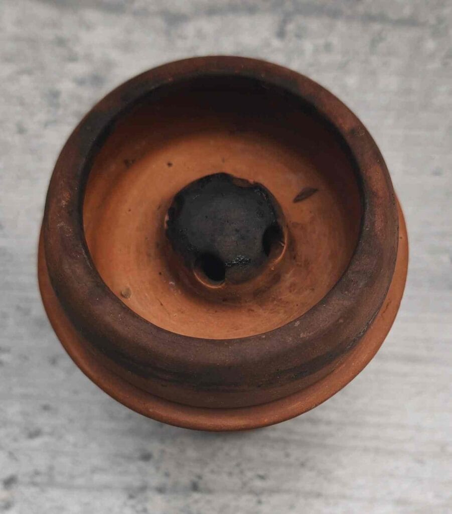 Nahaufnahme einer gebrauchten Shisha-Glasbowl mit Rußspuren.