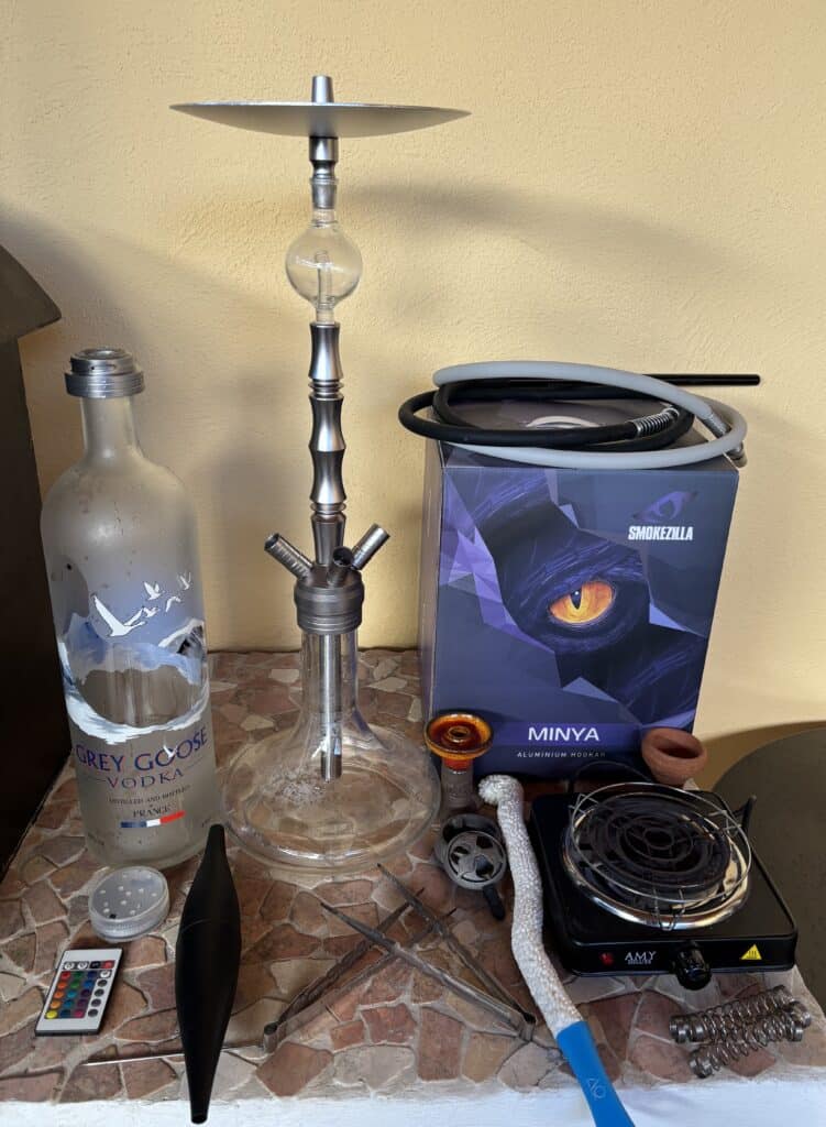 Verschiedene Shisha Teile, inklusive Glasbowl, Heizplatte und Zubehör.