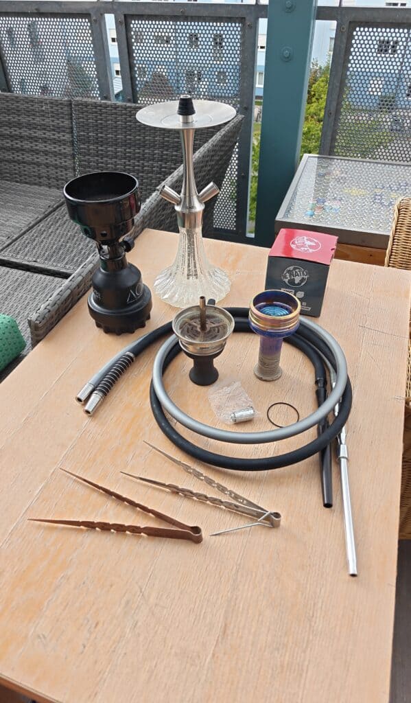Verschiedene Shisha Teile und Zubehör auf Tisch.
