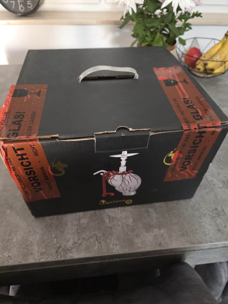 Originalverpackte Shisha-Glasbowl auf Tisch.