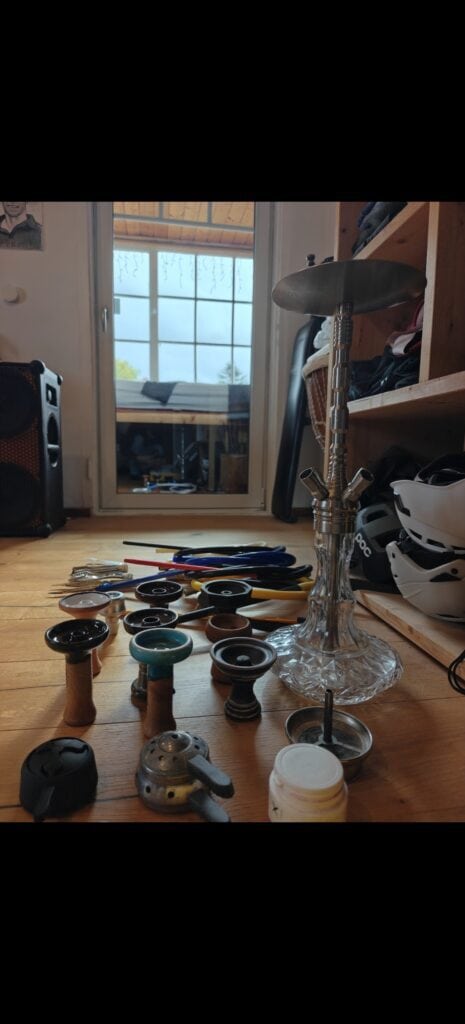Shisha Glasbowl und Ersatzteile auf Holztisch.