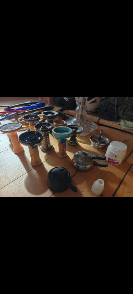 Shisha Glasbowl Set und Pfeifenständer auf Tisch.