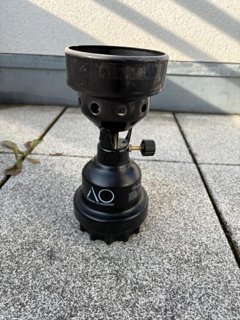 Schwarzer Shisha-Kopf mit Adapter auf Boden stehend.