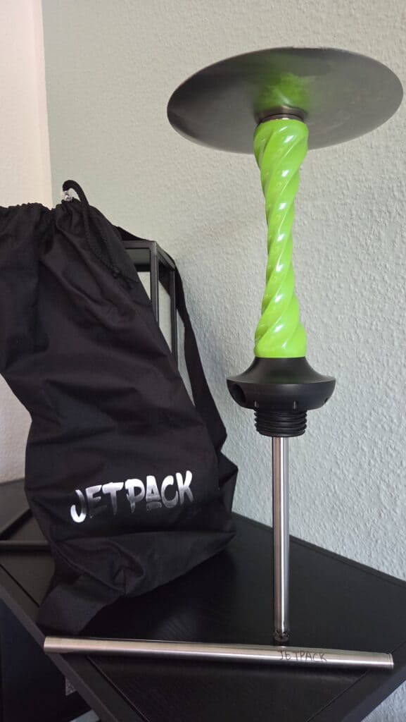 Grüne Glasbowl für Shisha-Hookah auf Tisch mit Tragetasche.