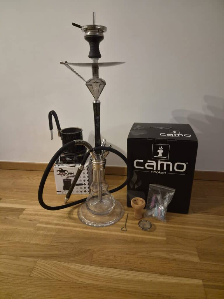 Verschiedene Shisha-Teile und Zubehör auf Holzboden.