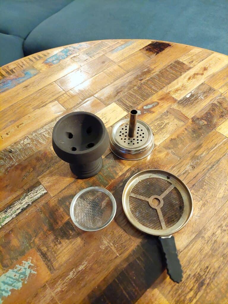 Verschiedene Shisha-Teile auf einem Holztisch.