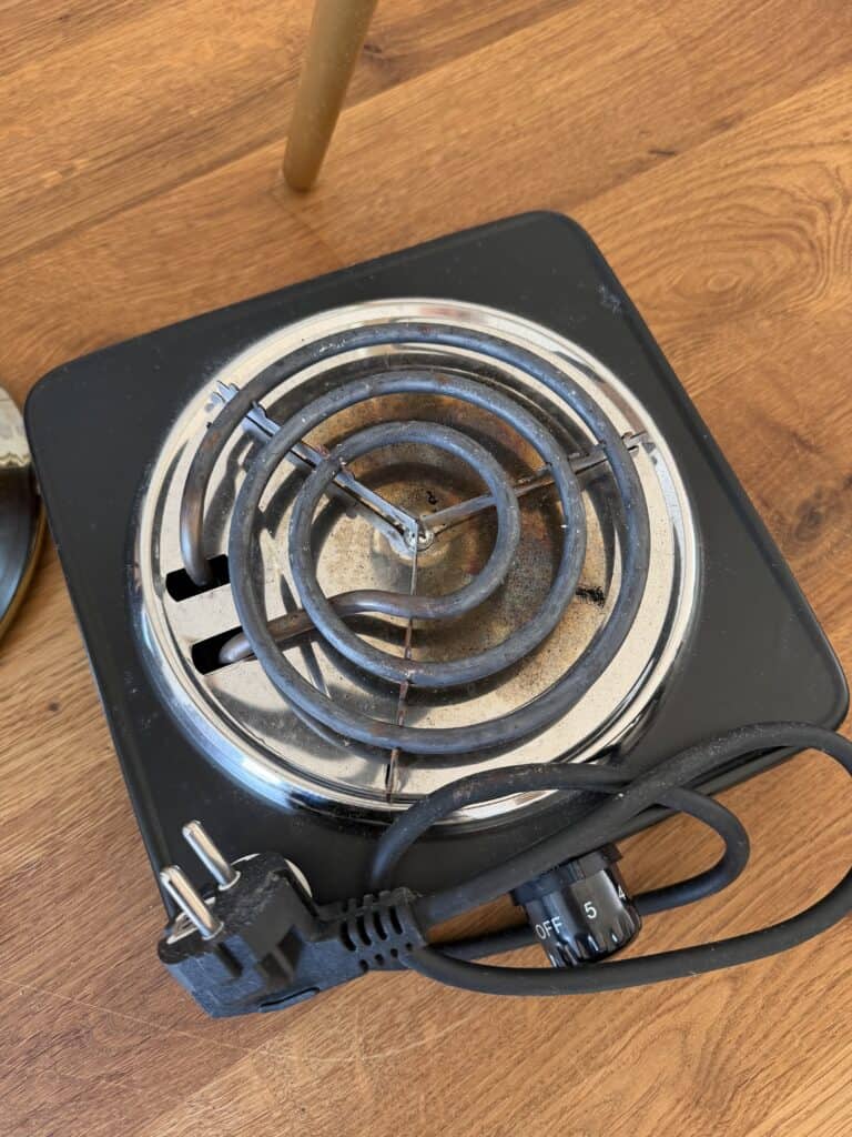 Kleine tragbare Kochplatte mit Spiralsicherung und Kabel.