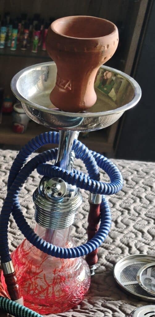 Nahaufnahme einer Shisha mit Glasbowl und Zubehör, Fokus auf die Glasbowl.
