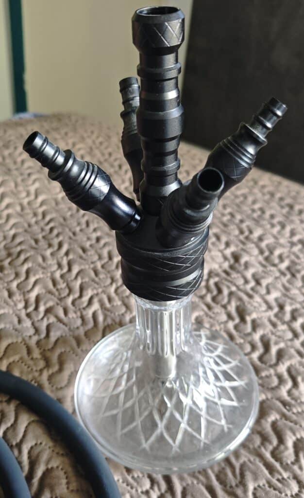 Mehrere schwarze Shisha-Adapter und Schlauchanschlüsse in einer Glasbowl.
