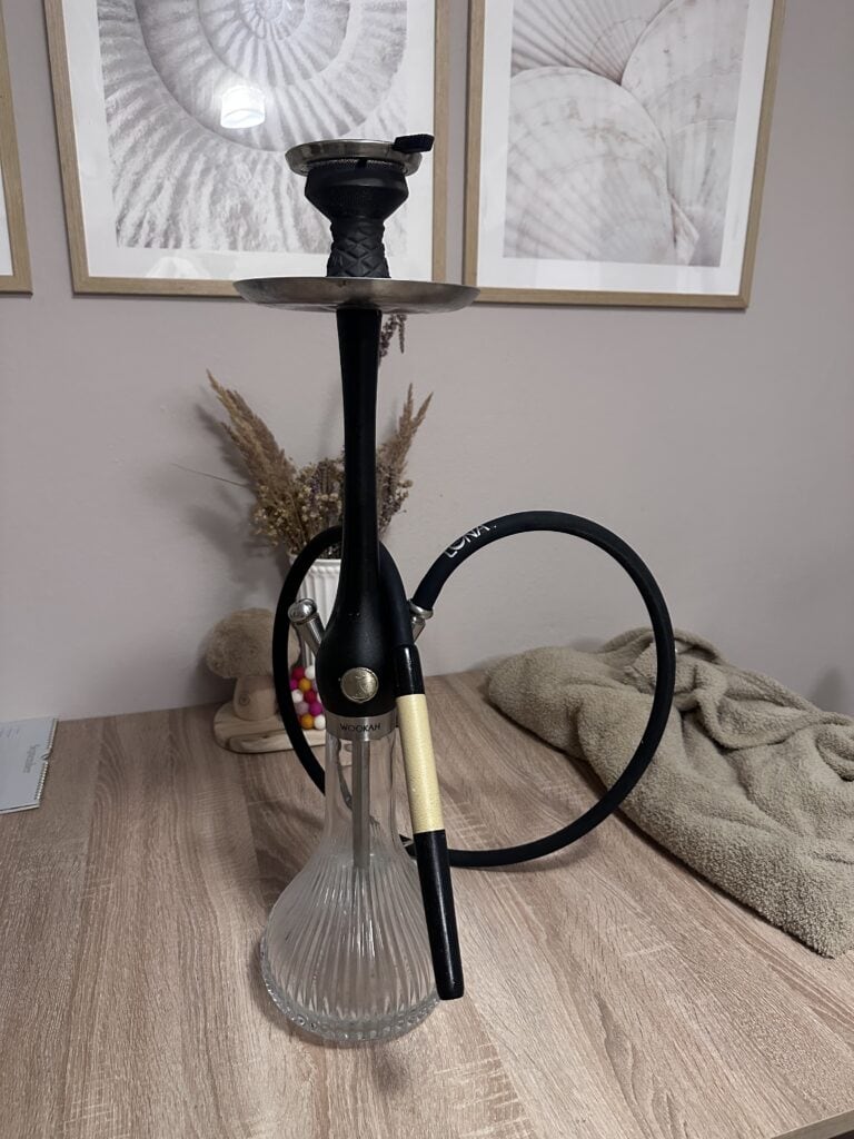 Schwarze Shisha mit Glasbowl auf Holztisch, Nahaufnahme.