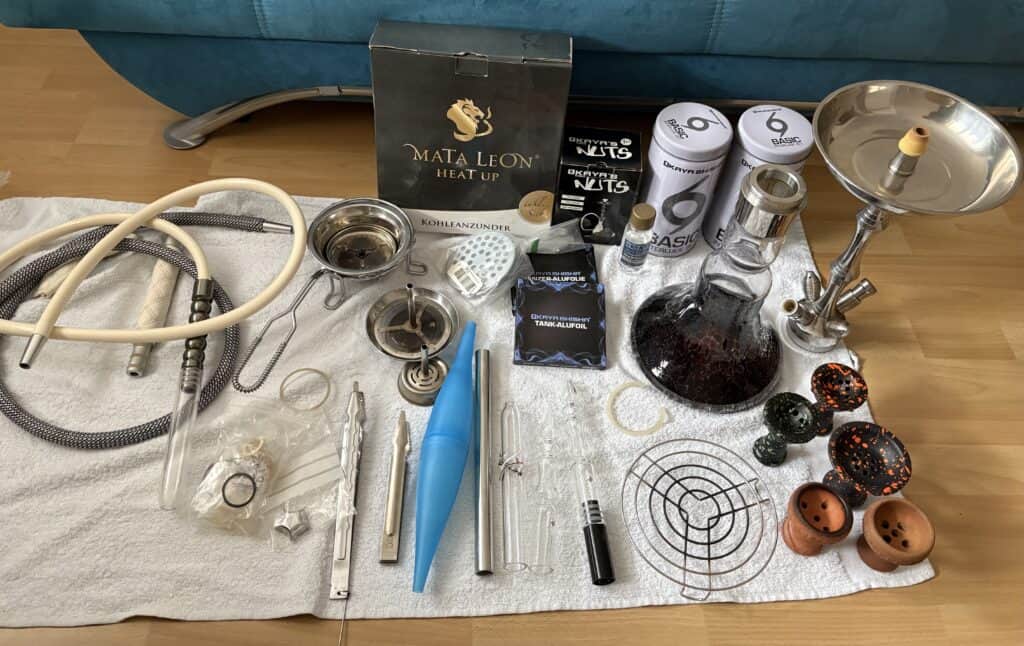 Shisha Glasbowl und Reinigungsteile auf Tisch.