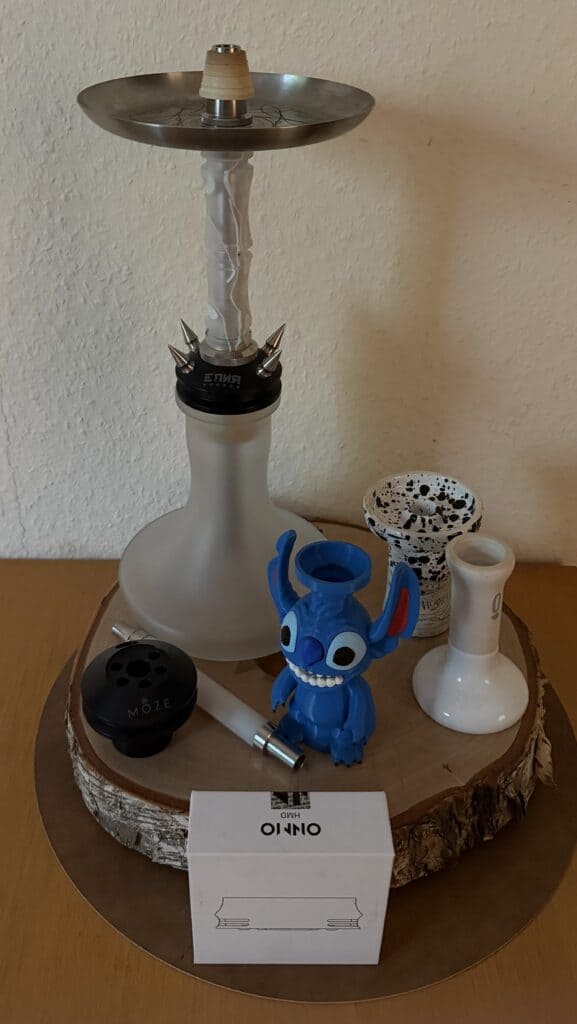 Verschiedene Shisha-Teile und Zubehör auf Holzplatte.
