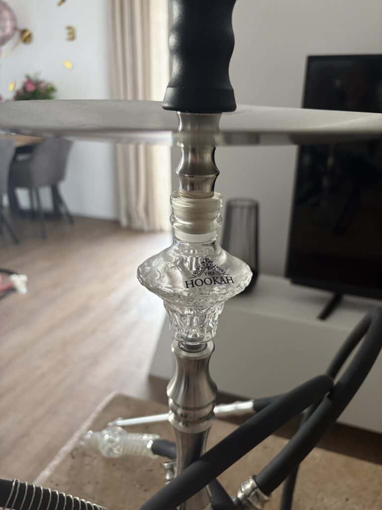Detailaufnahme einer Shisha-Glasbowl mit Metallverbindung und Schlauch.