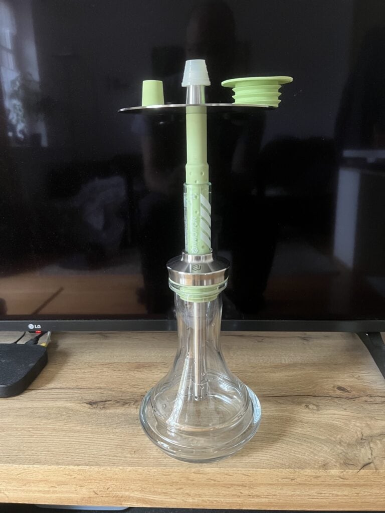 Transparente Glasbowl für Shisha mit grünem Zubehör und Aufsätzen.