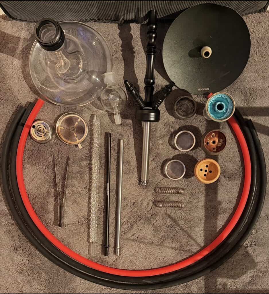 Verschiedene Shisha-Teile und Zubehör auf einem Tisch.
