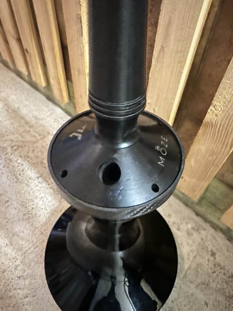 Schwarze Shisha mit Glasbowl und Metallrohr, auf Holztisch.