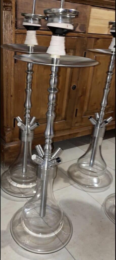 Großer Shisha-Tisch mit mehreren Glasbowl und Metallständern.