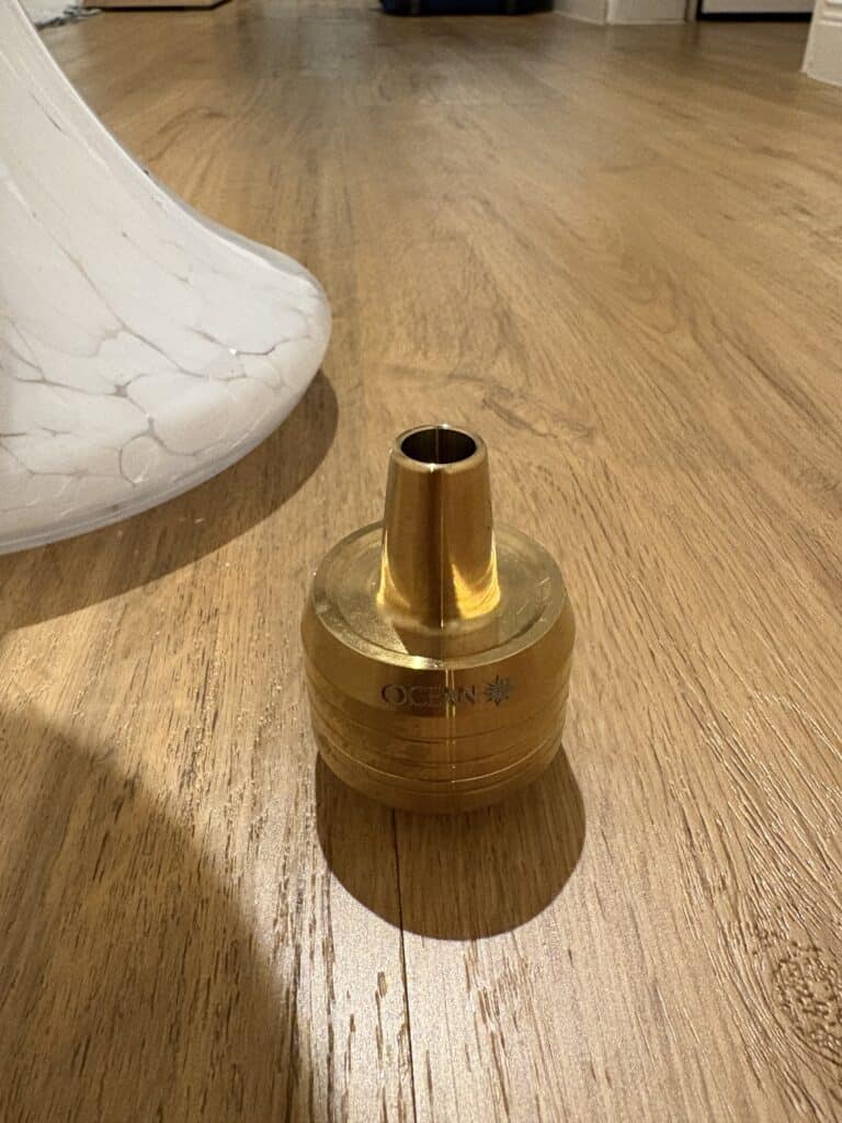 Goldene Glasbowl für Shisha, auf Holzboden.